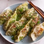 Homemade cabbage dumplings filled with seasoned cabbage and served with sauce.