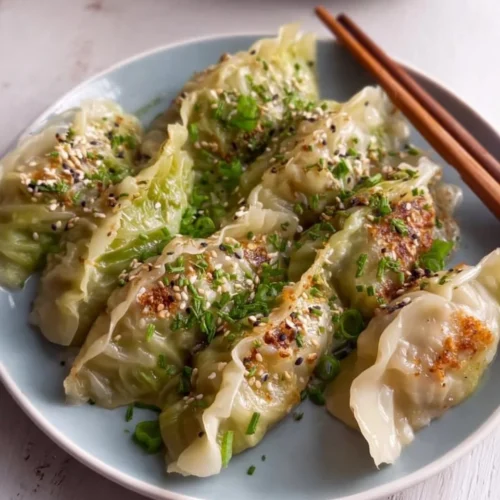 Homemade cabbage dumplings filled with seasoned cabbage and served with sauce.