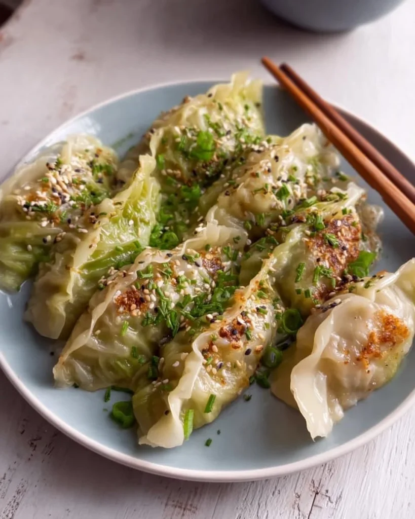 Homemade cabbage dumplings filled with seasoned cabbage and served with sauce.
