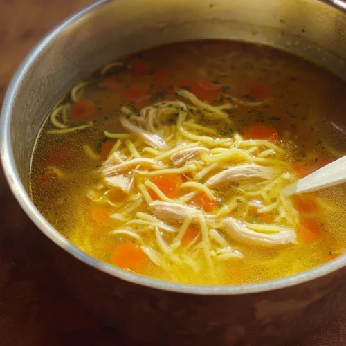 Bowl of Chicken Noodle Feel Better Soup with noodles, chicken, and vegetables