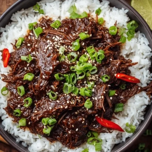 Delicious slow cooker Korean beef dish served with rice and garnished with green onions.