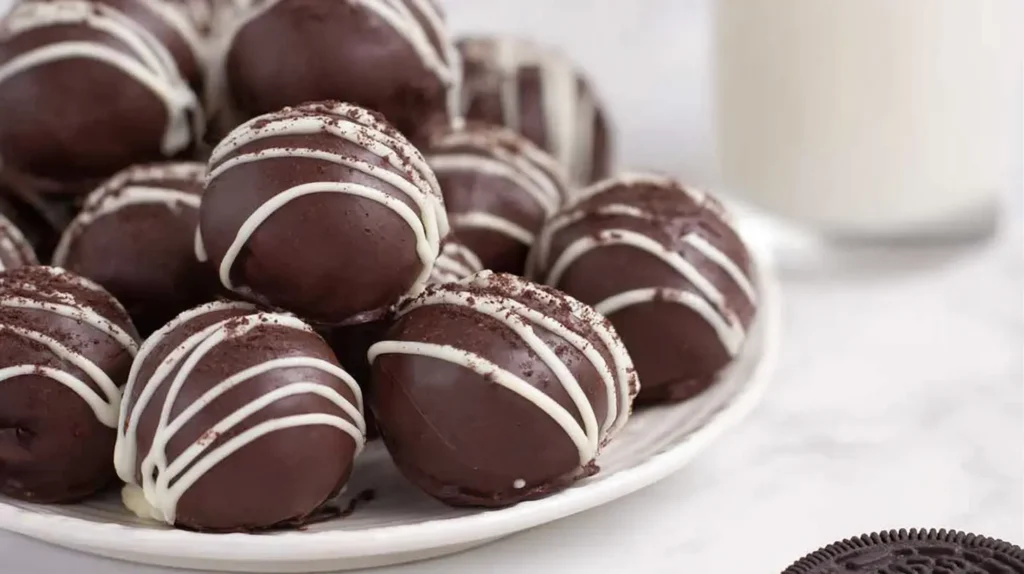 Assorted Oreo cream cheese balls, some rolled in crushed cookies, on a serving tray.