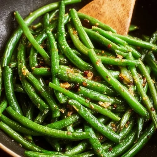 Plate of sautéed green beans with garlic and seasonings