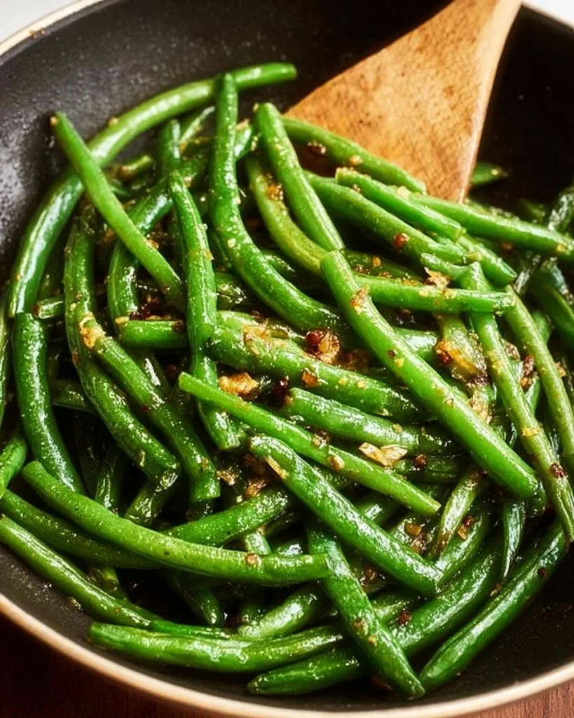 Plate of sautéed green beans with garlic and seasonings